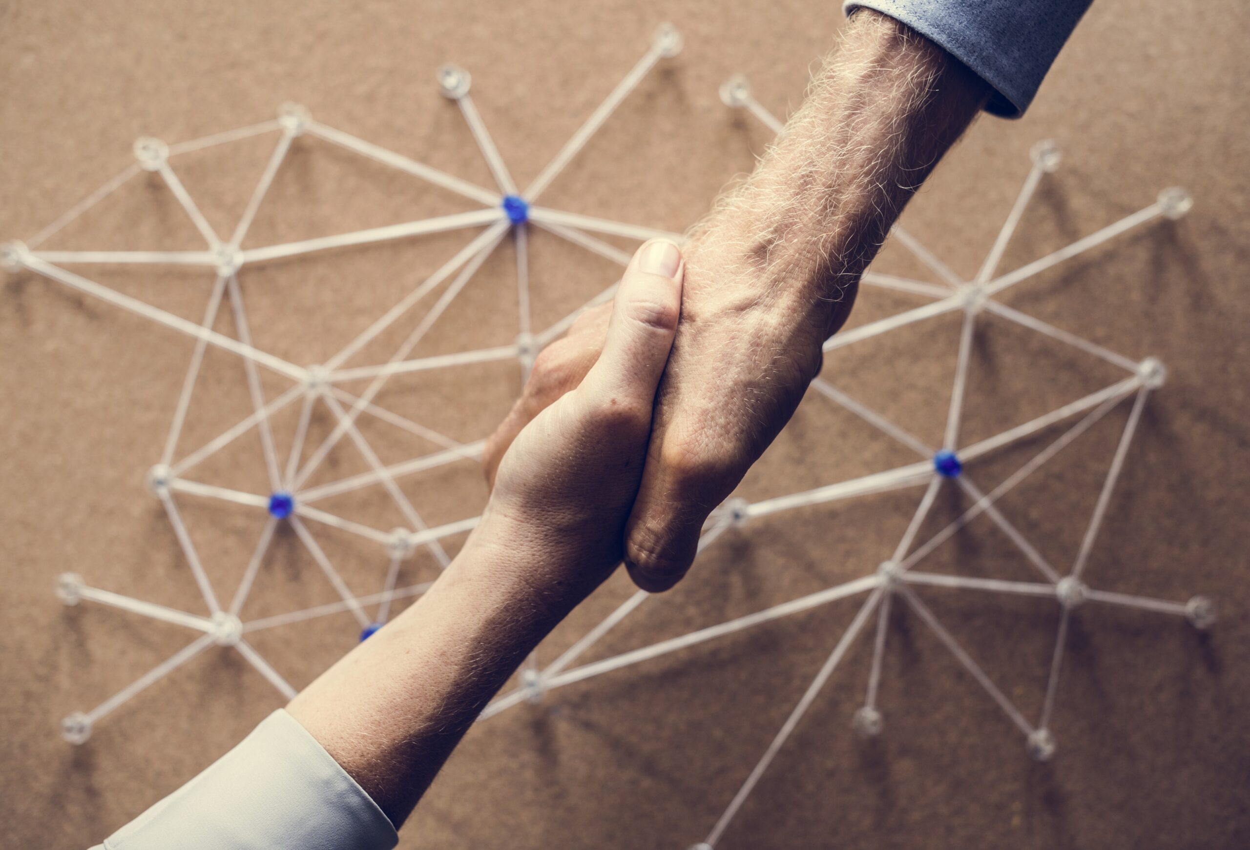 Two people shaking hands behind a customer acquisition strategy
